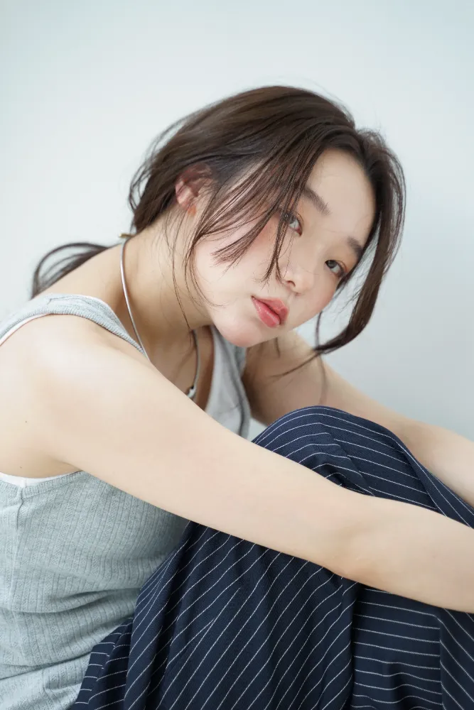 スタイル写真撮影、ポニーテールヘアのアップカット、頬に手を添えたポーズ