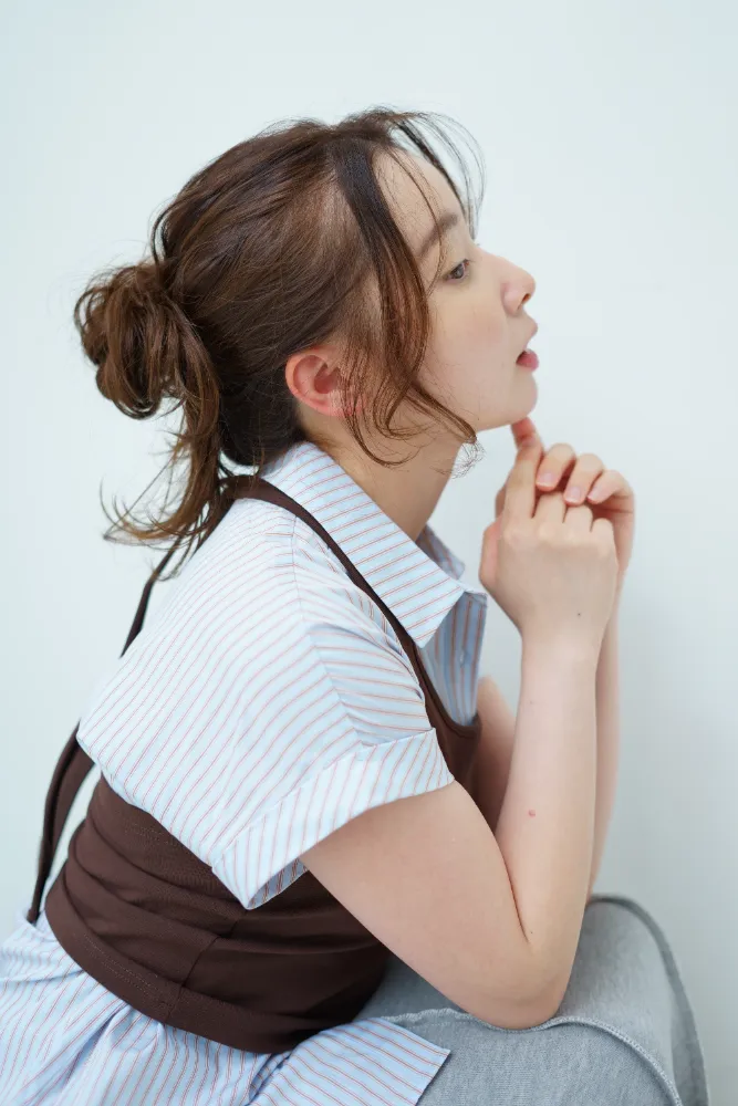 美容室モデル撮影、シニヨンヘアの横顔カット、あごに手を添えたポーズ